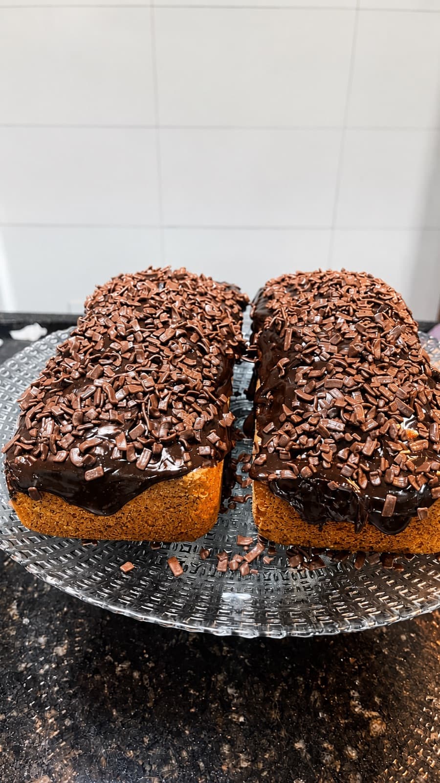 Bolo de chocolate com cobertura e raspas, feito na casa