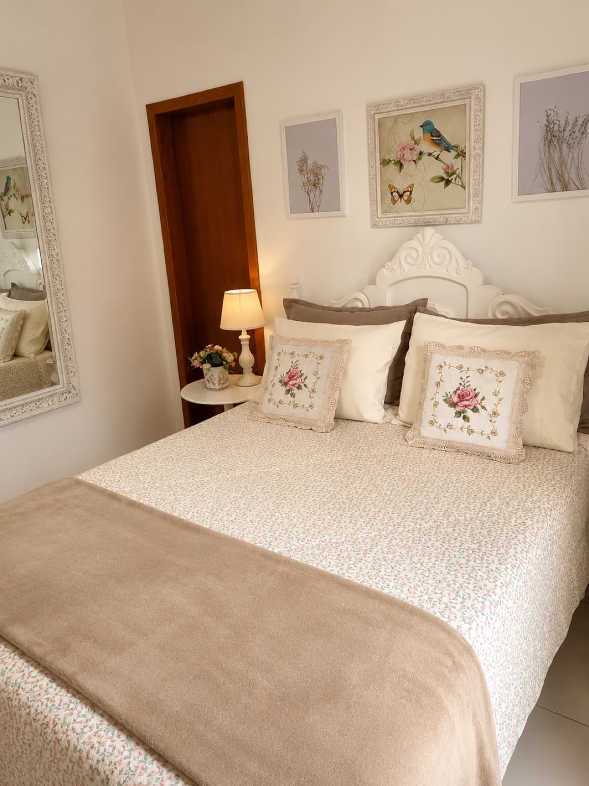 Quarto com cama de casal, cabeceira provençal e enxoval floral