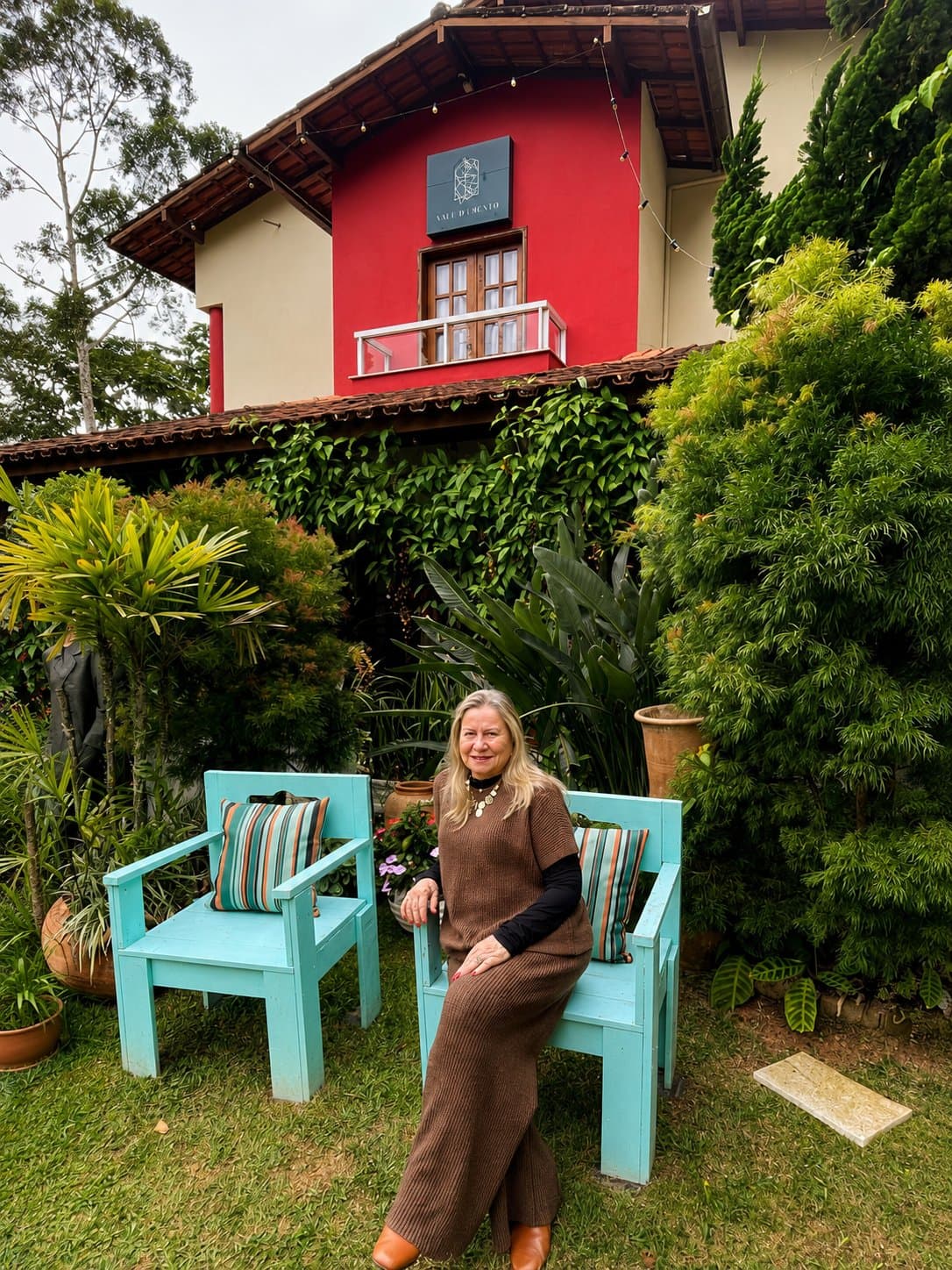 Dona Jurema no jardim da Pousada Valle di Trento, em frente à casa